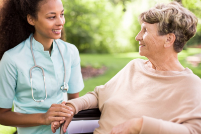 nurse holding the hands of the senior woman